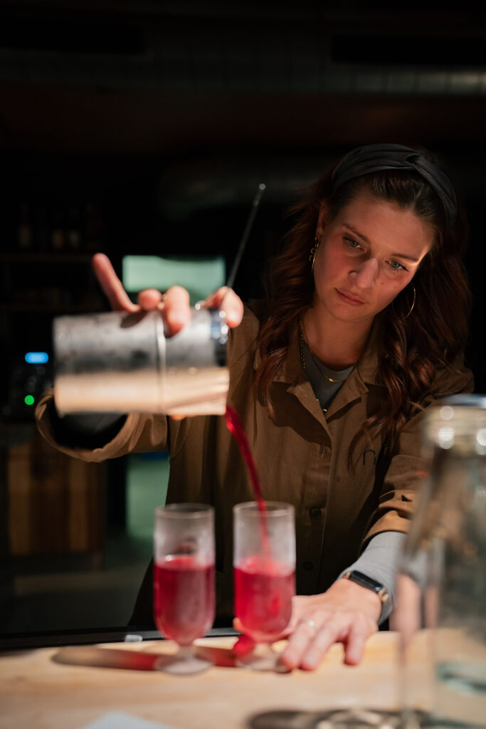 Bartenderin luisa beim einschenken eines Cocktails